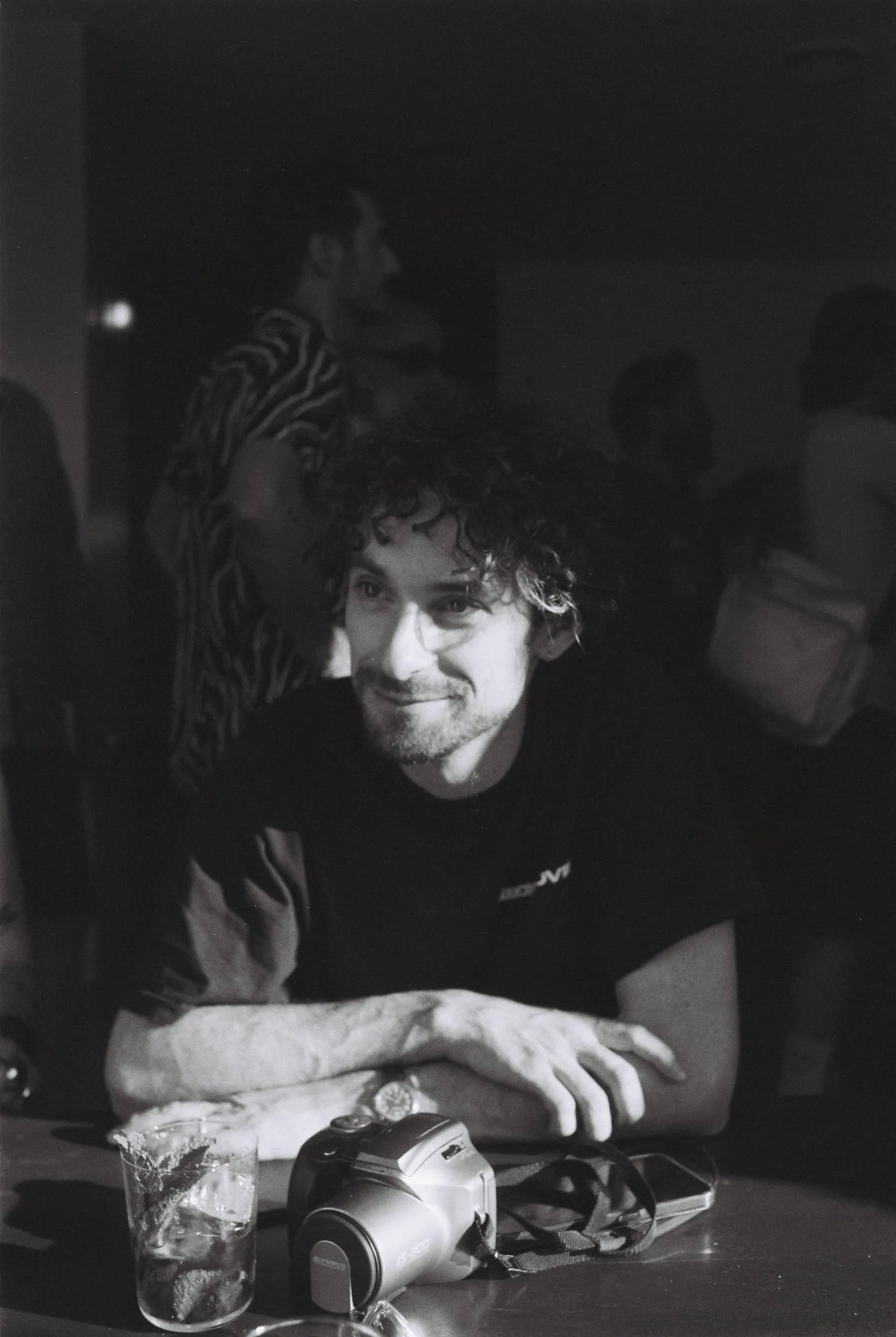 Man at a table with a camera, black and white